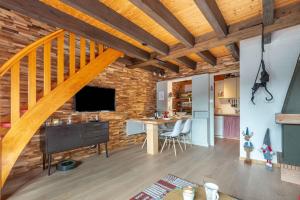 a loft with a staircase and a living room with a table at Kioné - duplex avec terrasse in La Bresse