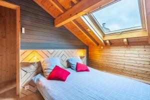 - une chambre avec un lit et 2 oreillers rouges dans l'établissement Kioné - duplex avec terrasse, à La Bresse