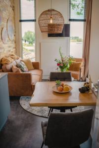 sala de estar con mesa y sofá en Holiday Home Tiny River House-1 by Interhome, en Maurik