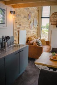 cocina y sala de estar con sofá en Holiday Home Tiny River House-1 by Interhome, en Maurik
