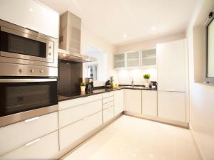 een keuken met witte kasten en roestvrijstalen apparaten bij Apartment Pine Hills Esmeralda by Interhome in Vilamoura +28 foto's