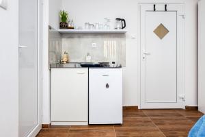 a kitchen with white cabinets and a sink at Captains room in Rovinj