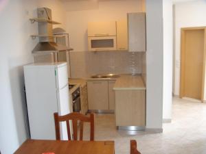 a kitchen with a white refrigerator and a table at Holiday Home Rubinić in Zavala