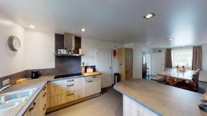 a large kitchen with a sink and a table at Valley View B&B with private wellness in Bullange