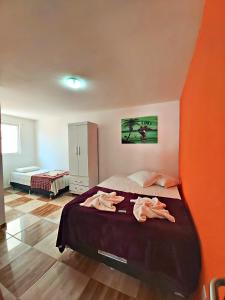um quarto com uma cama com uma parede laranja em Pousada Porto Amazônia em Porto de Galinhas