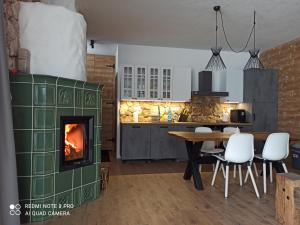 a kitchen with a table and a fireplace at Chata pod smrekmi in Hriňová