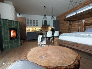 una camera con letto e tavolo con bicchiere da vino di Chata pod smrekmi a Hriňová