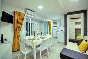 - une salle à manger et un salon avec une table et des chaises blanches dans l'établissement Village Camping Joker, à Cavallino-Treporti