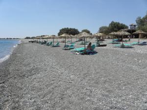 a group of chairs and umbrellas on a beach at Megim Hotel in Palaiochora