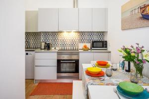 a kitchen with white cabinets and a table with plates on it at No. 7 Olhão in Olhão