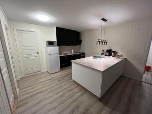 a kitchen with a counter and a white refrigerator at Tromsø stunning Luxury apart A in Larseng