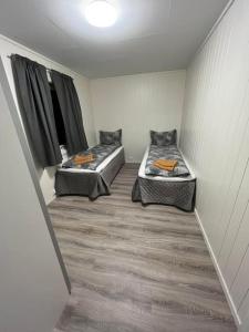 a room with two beds in a room at Tromsø stunning Luxury apart A in Larseng