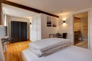 Schlafzimmer mit einem weißen Bett und einem TV in der Unterkunft Landgasthof am Königsweg in Ohmden