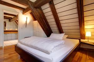 ein großes Bett in einem Zimmer mit Holzbalken in der Unterkunft Landgasthof am Königsweg in Ohmden