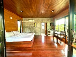 um quarto com uma cama e uma mesa num quarto em เพชรพิชชารีสอร์ท em Ban Bang Kham