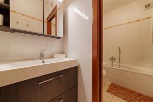 a bathroom with a sink and a toilet and a tub at Modern Lakefront 1-Bedroom Apartment in Acquaseria