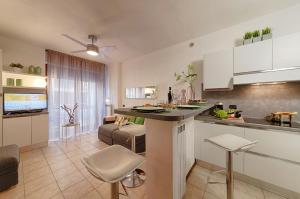 a kitchen and living room with a table and chairs at Modern Lakefront 1-Bedroom Apartment in Acquaseria