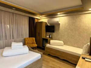 una habitación de hotel con dos camas y una silla en Golden Sail Hotel Old City, en Estambul