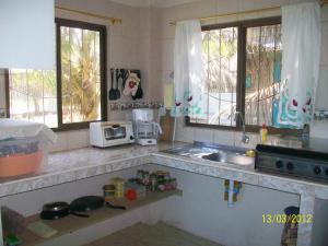 cocina con fregadero y 2 ventanas en Hostal Cabañas Vistamar, en Crucita