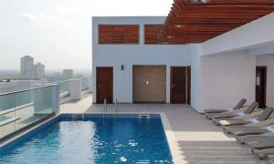 a swimming pool on top of a building with chairs at Adrich Properties Gallery in Accra