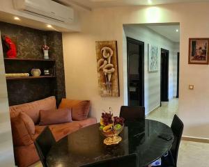 een woonkamer met een tafel en een bank bij Luxueux appartement Marrakech au cœur de l hivernage in Marrakesh