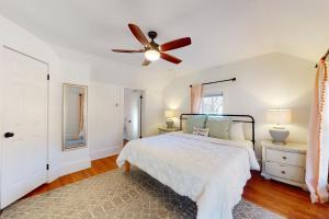 1 dormitorio con 1 cama y ventilador de techo en The Pink House on Main - Upper, en Eureka Springs