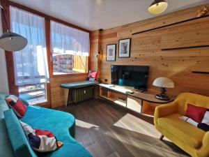 a living room with a blue couch and a television at Hostdomus - Oslo Apartments in Borgata Sestriere