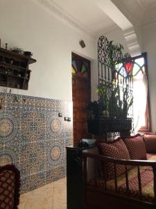 una sala de estar con sofá y una puerta con vidrieras. en Appartement meublé 5 personnes en plein centre ville, en Rabat