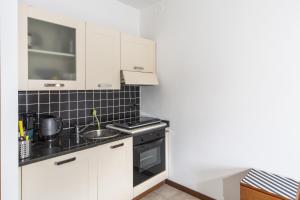 een keuken met witte kasten en een fornuis met oven bij Studio Apartment Vista Panoramica in Acquaseria