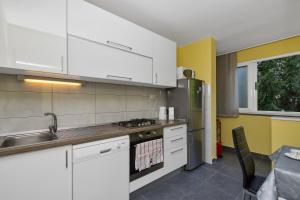 eine Küche mit weißen Schränken, einer Spüle und einem Herd in der Unterkunft Apartman Goranka in Makarska