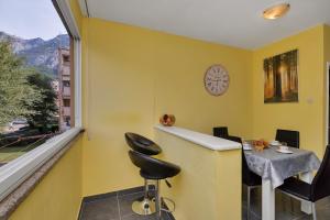 gelbes Zimmer mit einem Tisch, Stühlen und einem Fenster in der Unterkunft Apartman Goranka in Makarska