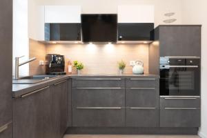 una cocina con armarios y electrodomésticos de color marrón oscuro. en Nienhagener Weg 2 MeerFlair, en Grömitz