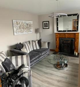uma sala de estar com um sofá e uma lareira em Hopefield House, Portrush em Portrush