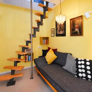 a living room with a couch and a spiral staircase at Vogelmann Suite in Pfronten