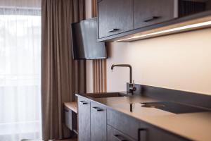 eine Küche mit einem Waschbecken und einem Fenster in der Unterkunft ROUDA luxury retreat am Kronplatz in Olang