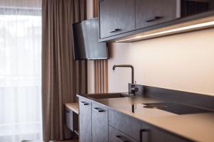 kuchnia ze zlewem i oknem w obiekcie ROUDA luxury retreat am Kronplatz w mieście Valdaora