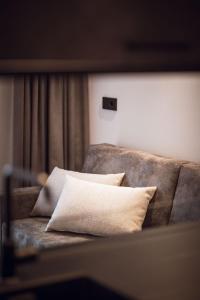 kanapę z poduszkami w pokoju w obiekcie ROUDA luxury retreat am Kronplatz w mieście Valdaora