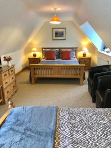 a bedroom with a king sized bed and a couch at Cornerways B&B in Chipping Campden