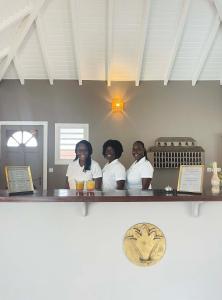 a group of three women sitting at a bar at Hotel La Plantation in Orient Bay