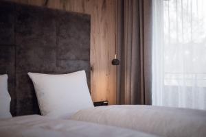 sypialnia z 2 białymi łóżkami i oknem w obiekcie ROUDA luxury retreat am Kronplatz w mieście Valdaora +13 zdjęć