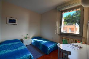 Zimmer mit 2 Betten, einem Tisch und einem Fenster in der Unterkunft 2-Bedroom Lakeview Apartment Bella Gaeta in San Siro