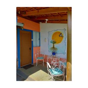um pátio com cadeiras e uma mesa numa casa em Pousada Sítio São Pedro em Delfinópolis
