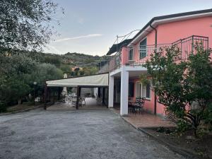 a pink building with a tent in front of it at Agriturismo Le Mimose in Imperia