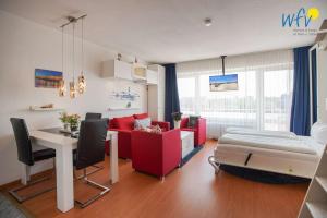 a living room with a red couch and a table at Holiday Residenz - Ferienwohnung "Kuestenkind" in Borkum