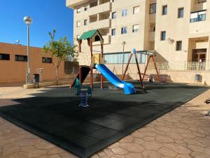 un parque infantil con un tobogán frente a un edificio en Apartamento en Jerez de la Frontera en Jerez de la Frontera