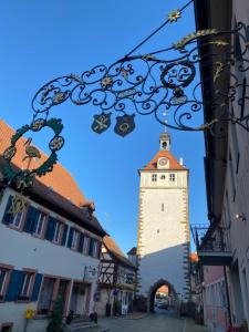 a building with a clock tower in the middle of a street at Gasthof zum Storch in Prichsenstadt