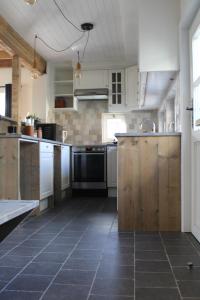uma grande cozinha com armários brancos e piso em azulejo em 't Jongehof 