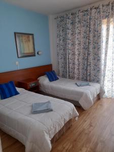 a hotel room with two beds and a window at Onisillos Hotel in Larnaka