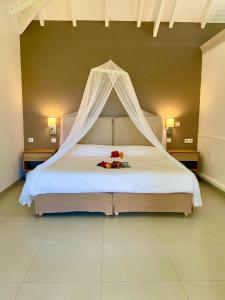 a large bed with a canopy in a room at Hotel La Plantation in Orient Bay