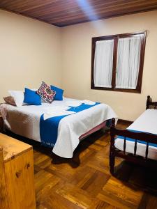 a bedroom with two beds and a window at Casa Bela vista in Campos do Jordão